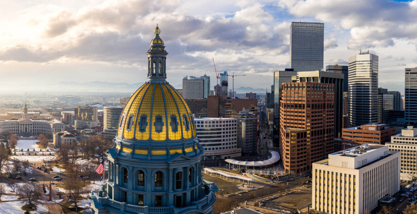 A skyline view of Denver with the gold dome of the Colorado state capitol building