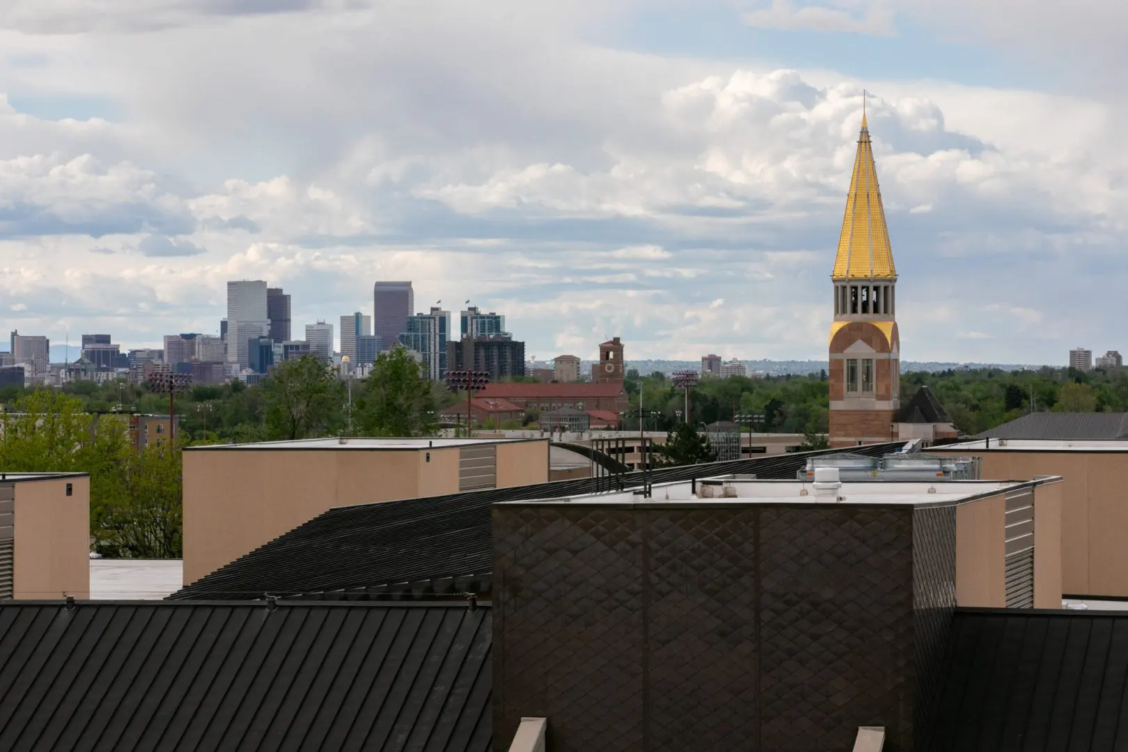A skyline view of the university of denver campus with a gold spire