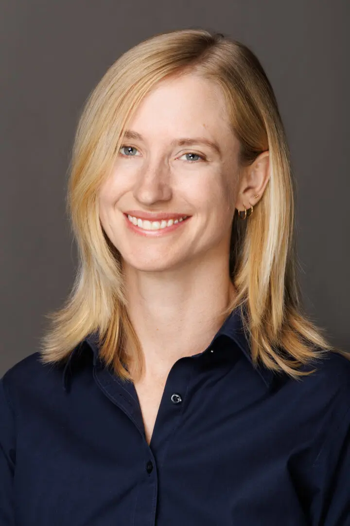 a blonde woman in a black button up blouse