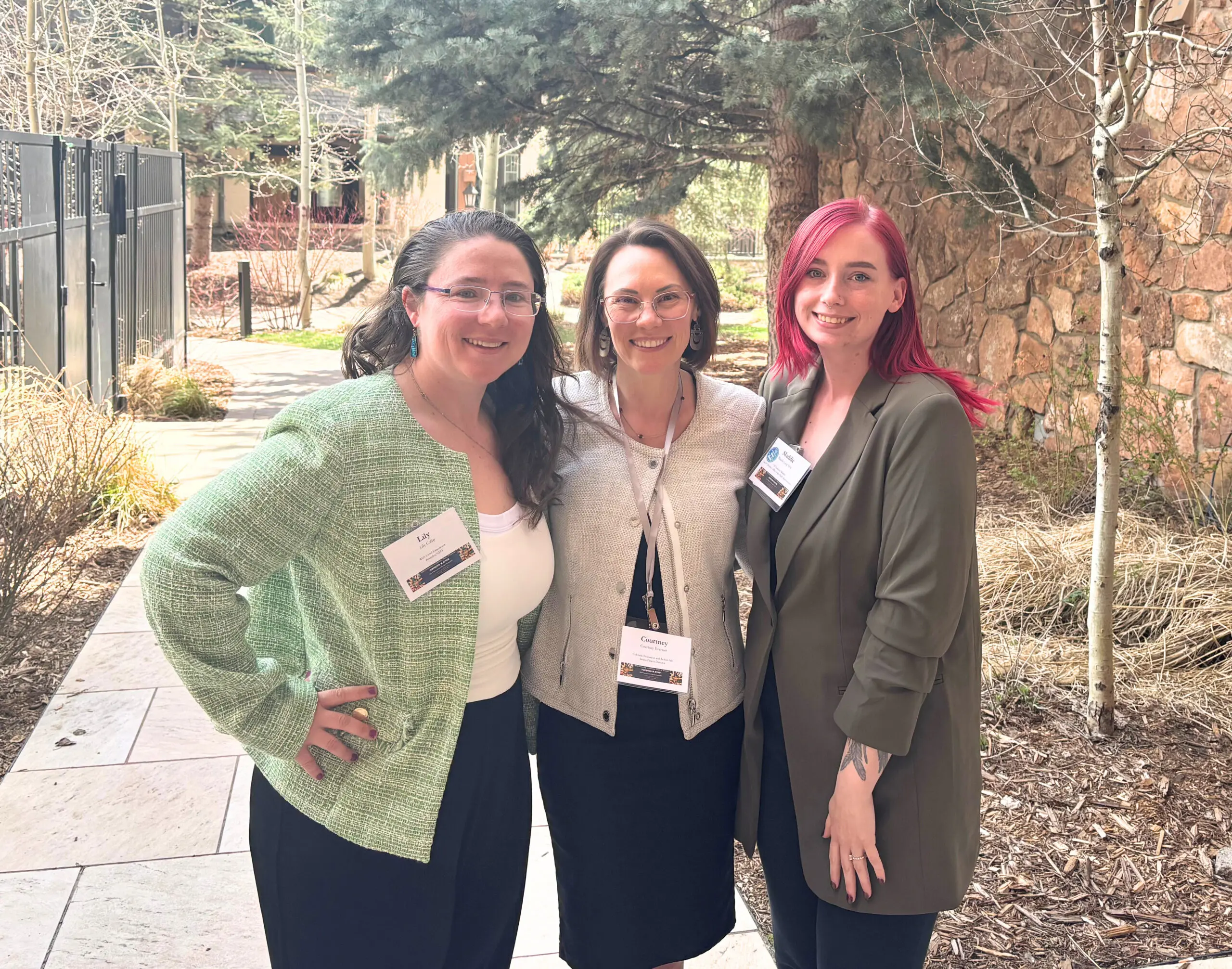 three women take a photo outside of a conference