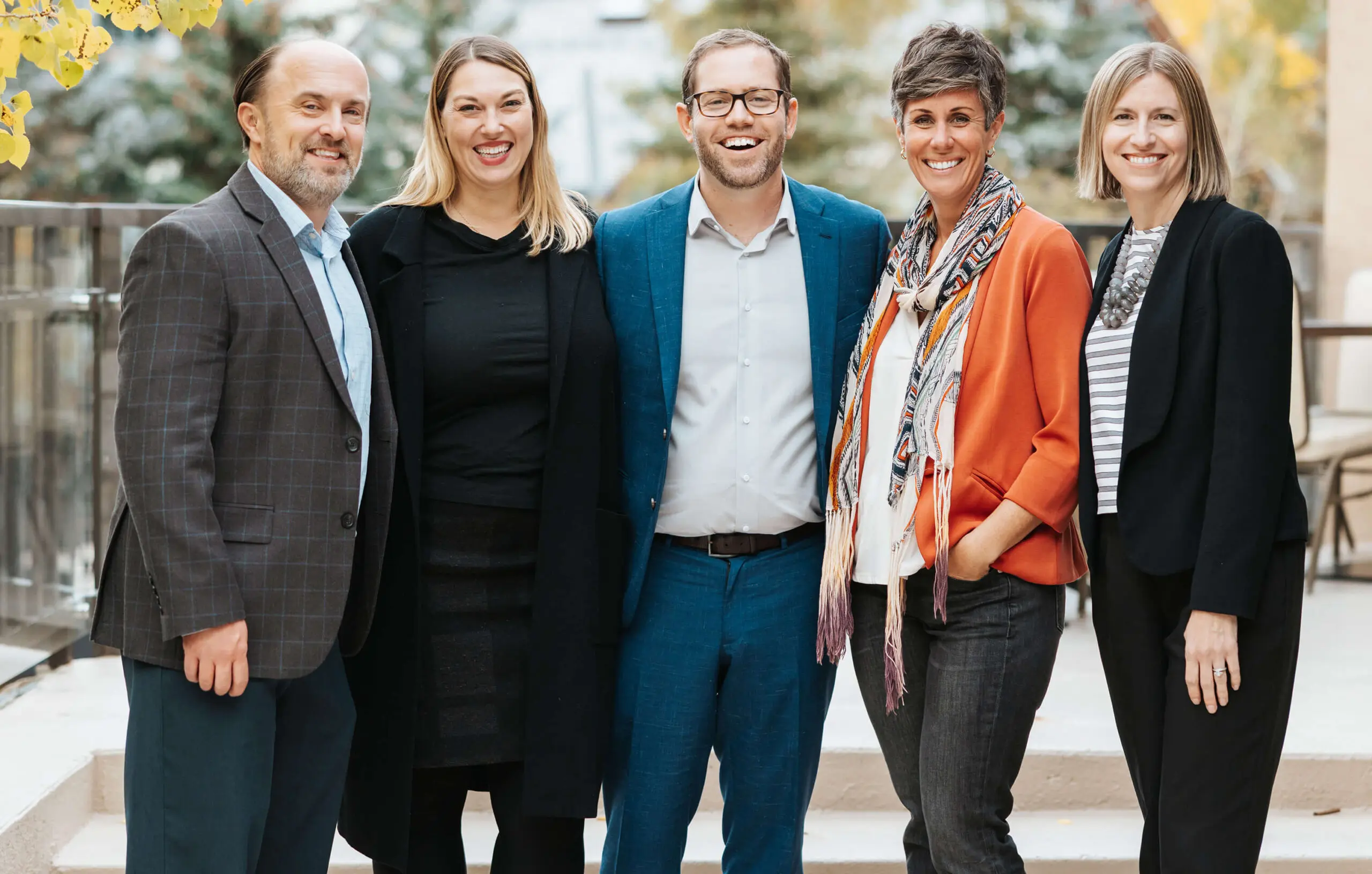 a group of five professionals pose for a photo