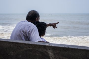 grandfather and grandchild looking at ocean