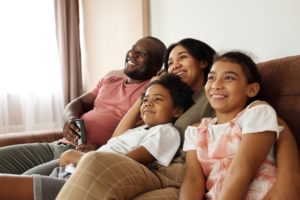 family of four at home on couch