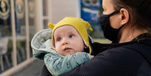 COVID masked mother holding baby