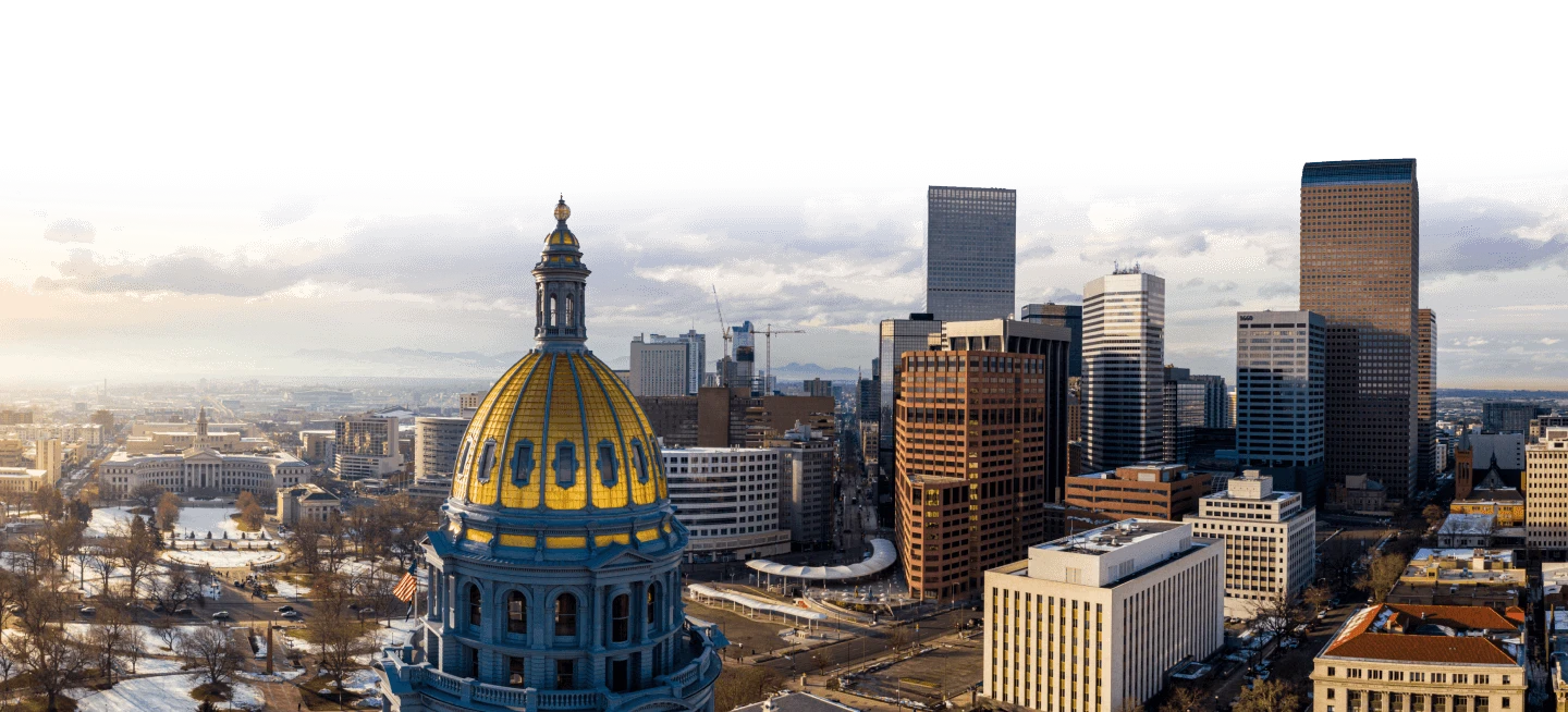 A skyline view of Denver with the gold dome of the Colorado state capitol building
