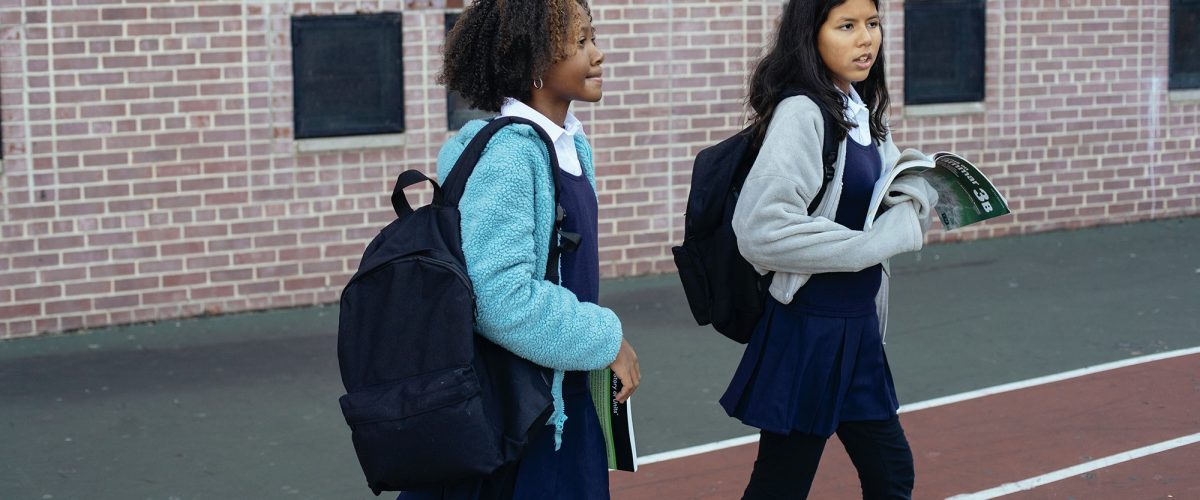 two minority female students walking together at school